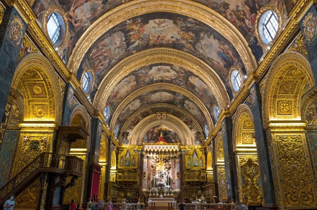 Lavishly decorated interior of St. John’s Co-Cathedral in Valletta, Malta, with gold ornamentation and painted vaulted ceiling. Malta travel guide