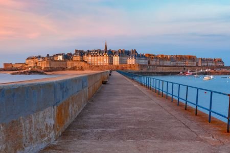 View of Saint-Malo’s old town and sea walls at sunset, Brittany. Retiring in France.
