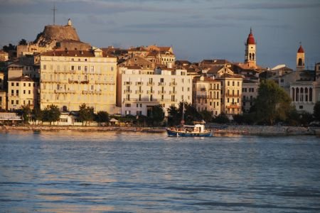 Corfu Old Town waterfront with traditional buildings and fishing boat, Greece