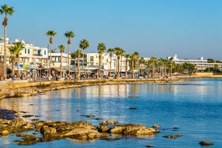 Paphos seafront promenade and palm-lined waterfront at sunset.